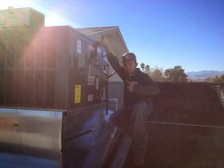 HVAC technician performing AC Tune-Up on a rooftop unit in Westwood Lakes